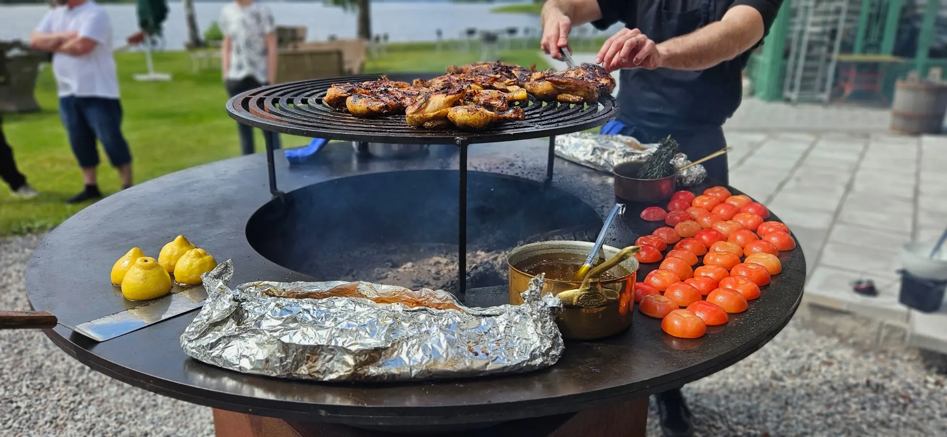 Grillkväll på Sjötullen – kocken grillar kyckling över öppen eld med utsikt över sjön